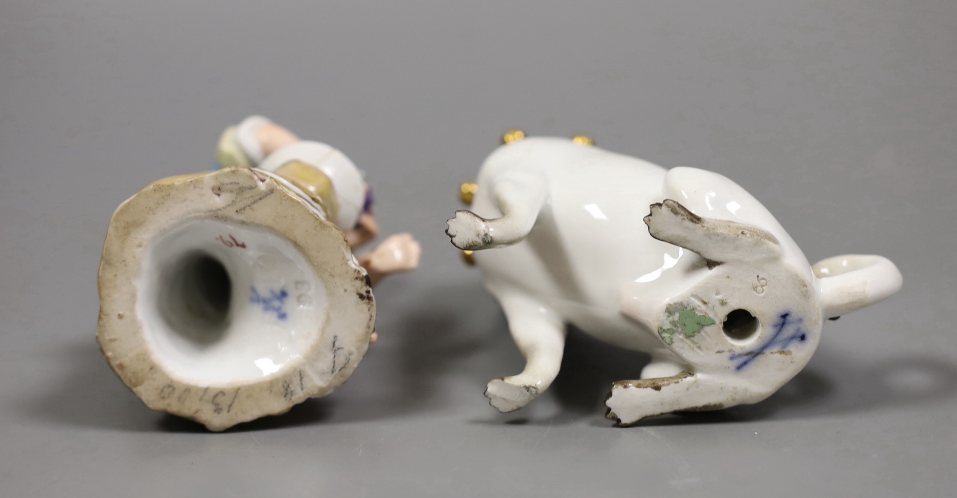 A late 19th century Meissen figure of a pug and a similar seated figure of a boy, tallest 10.5cm